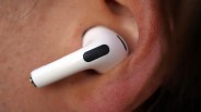 White wireless earbud inserted in a person's ear.