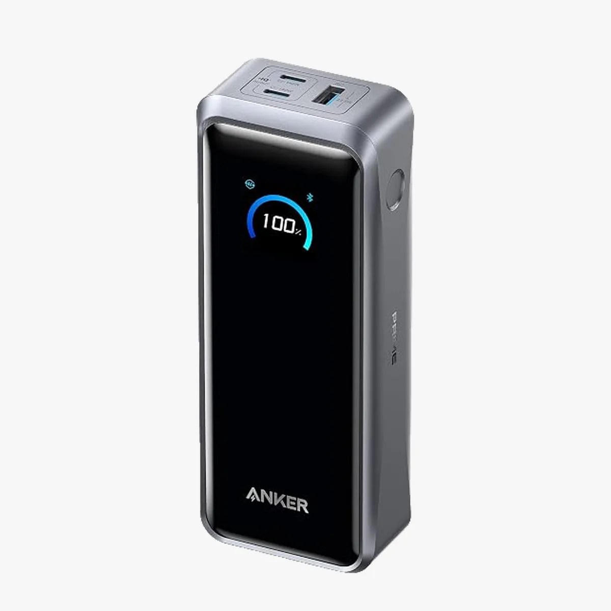 Rectangular Anker portable charger with digital display showing 100% battery, USB and USB-C ports on top.