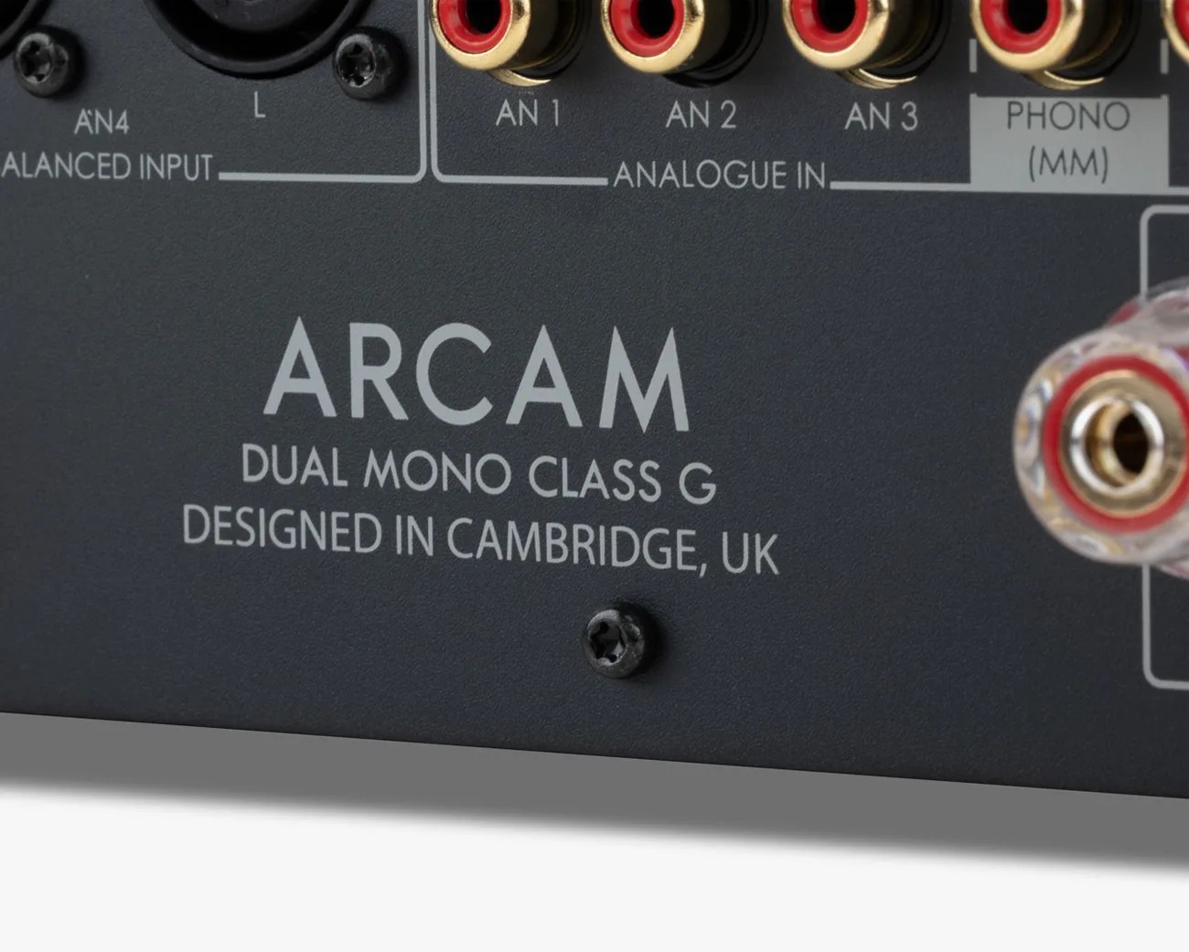 Close-up of the back panel of an Arcam audio device showing RCA connectors and text "DUAL MONO CLASS G DESIGNED IN CAMBRIDGE, UK.