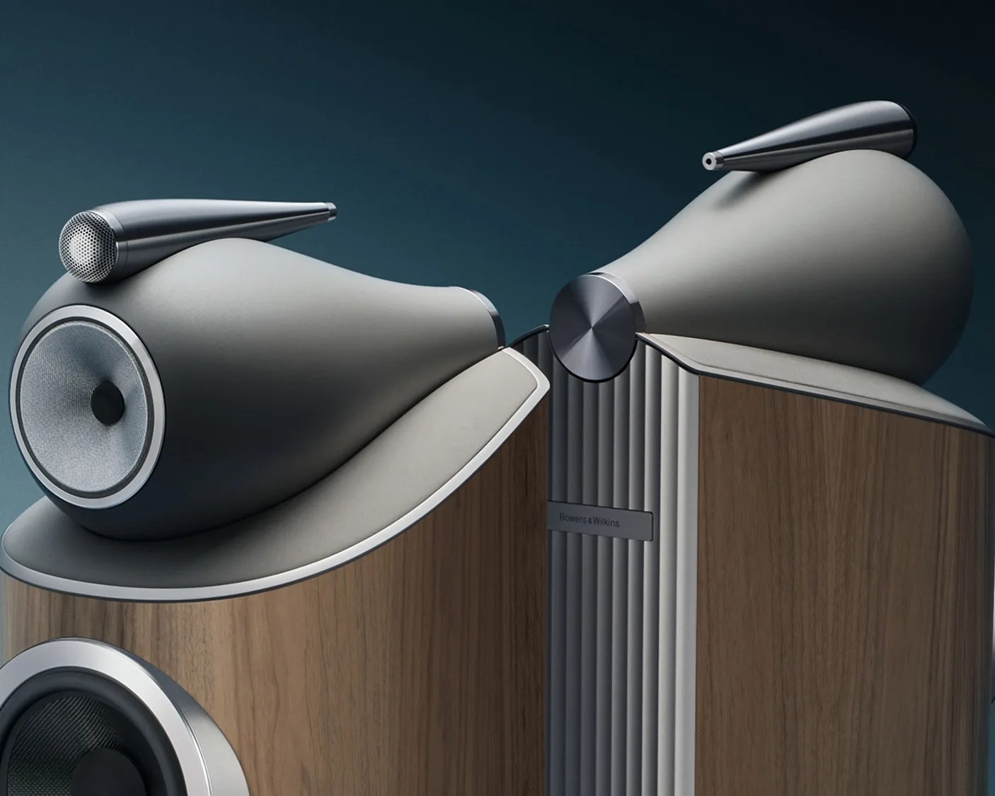 Pair of Bowers & Wilkins speakers with wooden cabinets and gray, sculpted upper sections with metal tweeters.
