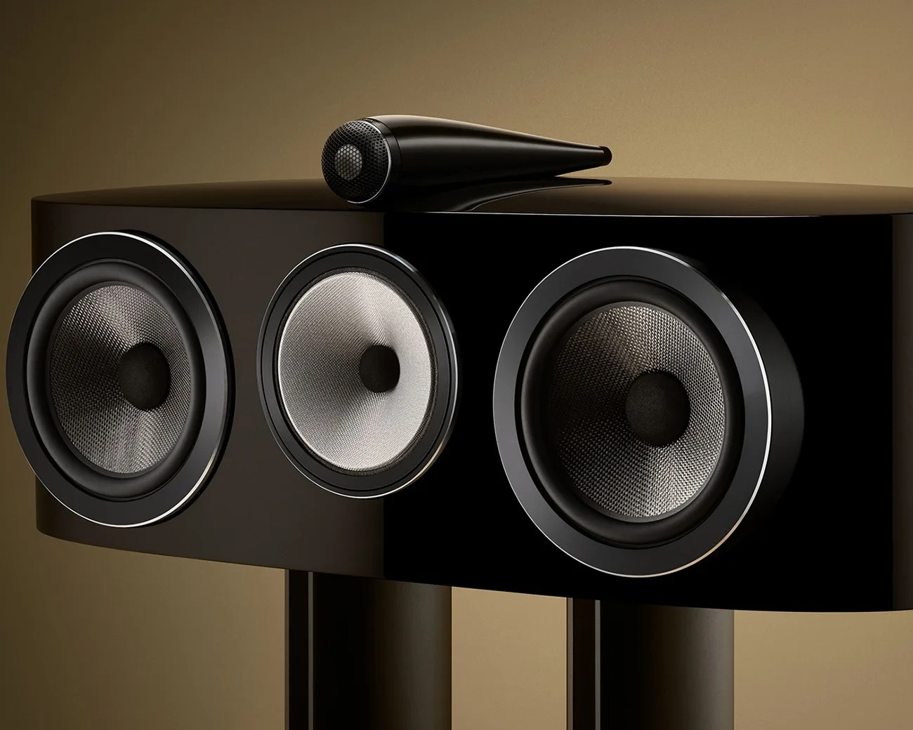 Glossy black speaker with three silver cone drivers and a small black tweeter on top.