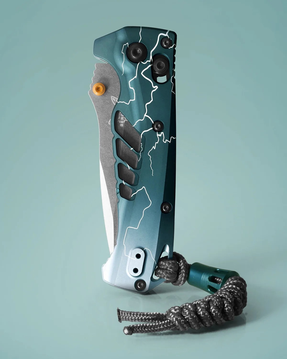 Folded tactical knife with a blue handle featuring white lightning patterns and a black braided lanyard.