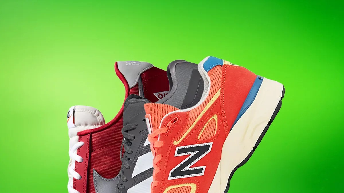 Three athletic sneakers in red, gray, and orange with black and white accents against a green background.