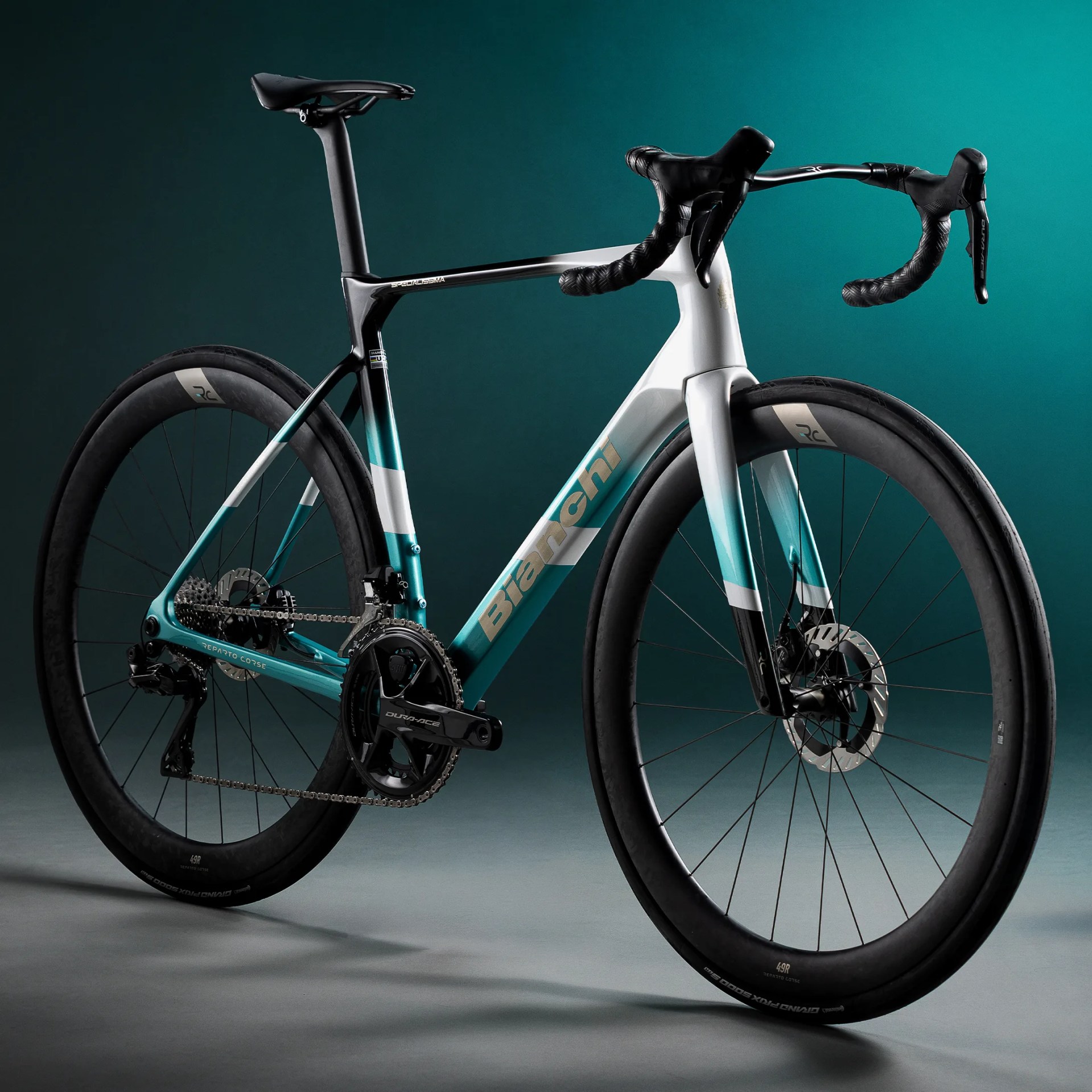 A Bianchi road bike with a black, white, and teal frame, black handlebars, and deep-section carbon wheels.