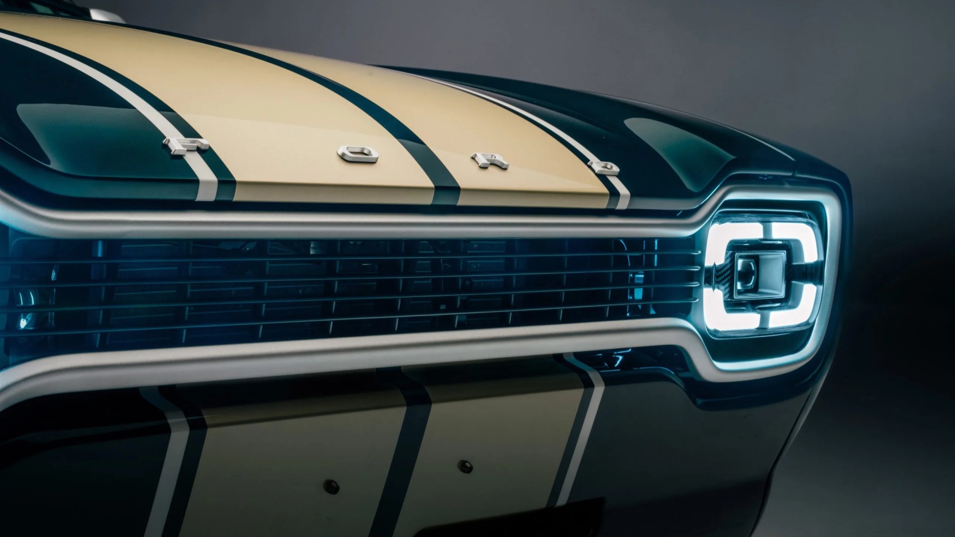 Close-up of a dark green Ford car front with cream racing stripes and illuminated square LED headlight.