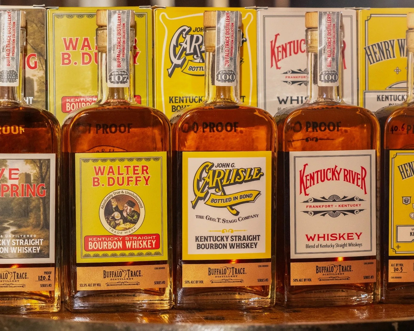 Five bottles of Buffalo Trace Distillery bourbon whiskey lined up, each with distinct labels including Walter B. Duffy, John G. Carlisle, and Kentucky River.