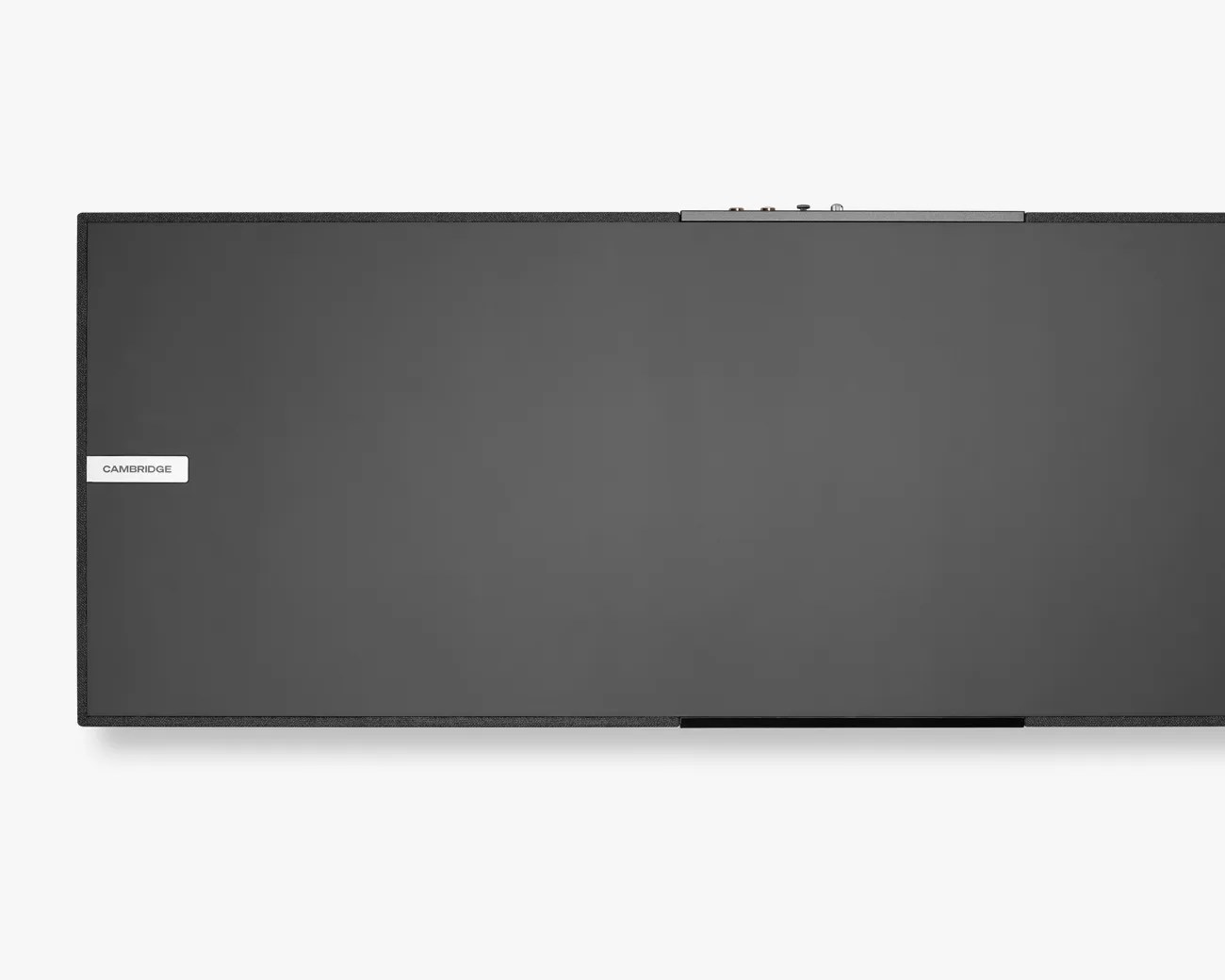 Black rectangular Cambridge audio speaker with a fabric-covered frame and control panel on top.