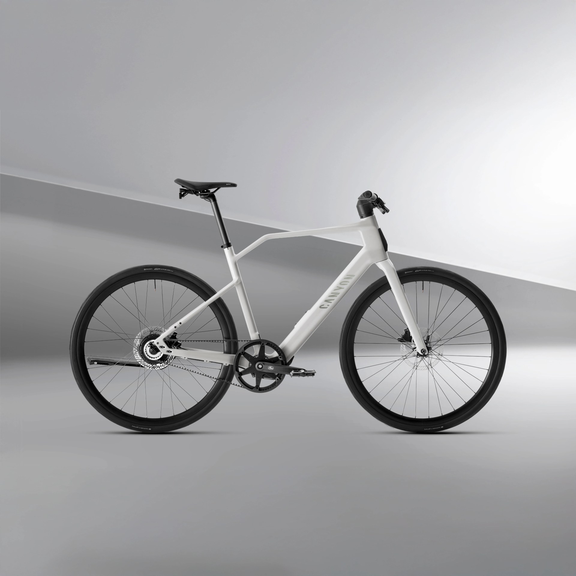 White Canyon road bike with black saddle, black tires, and minimalist frame design against a gray background.