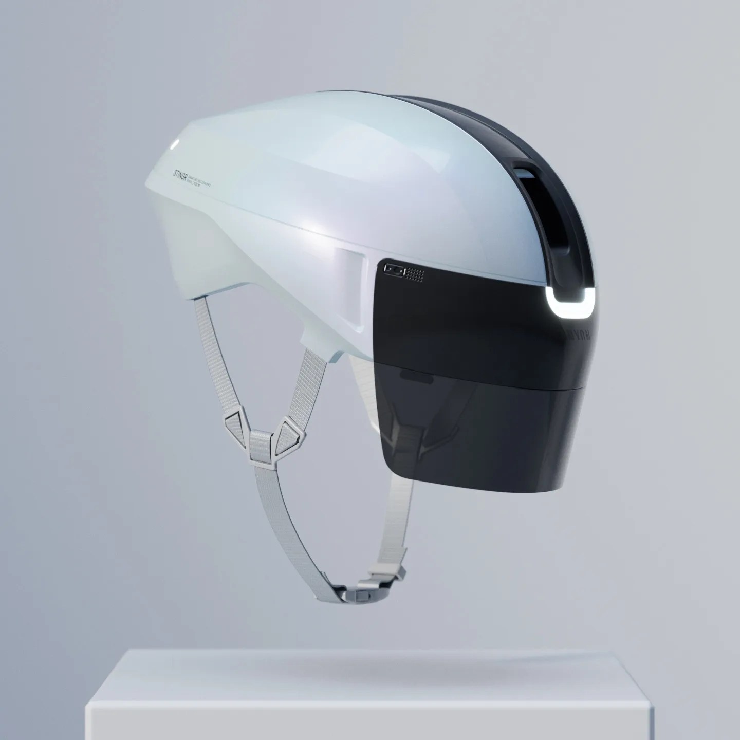 White and black futuristic bike helmet with integrated rear light and adjustable gray straps on a white pedestal.