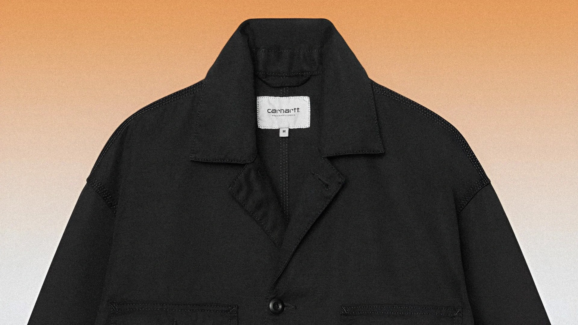 Black Carhartt jacket with collar and button closure on an orange gradient background.