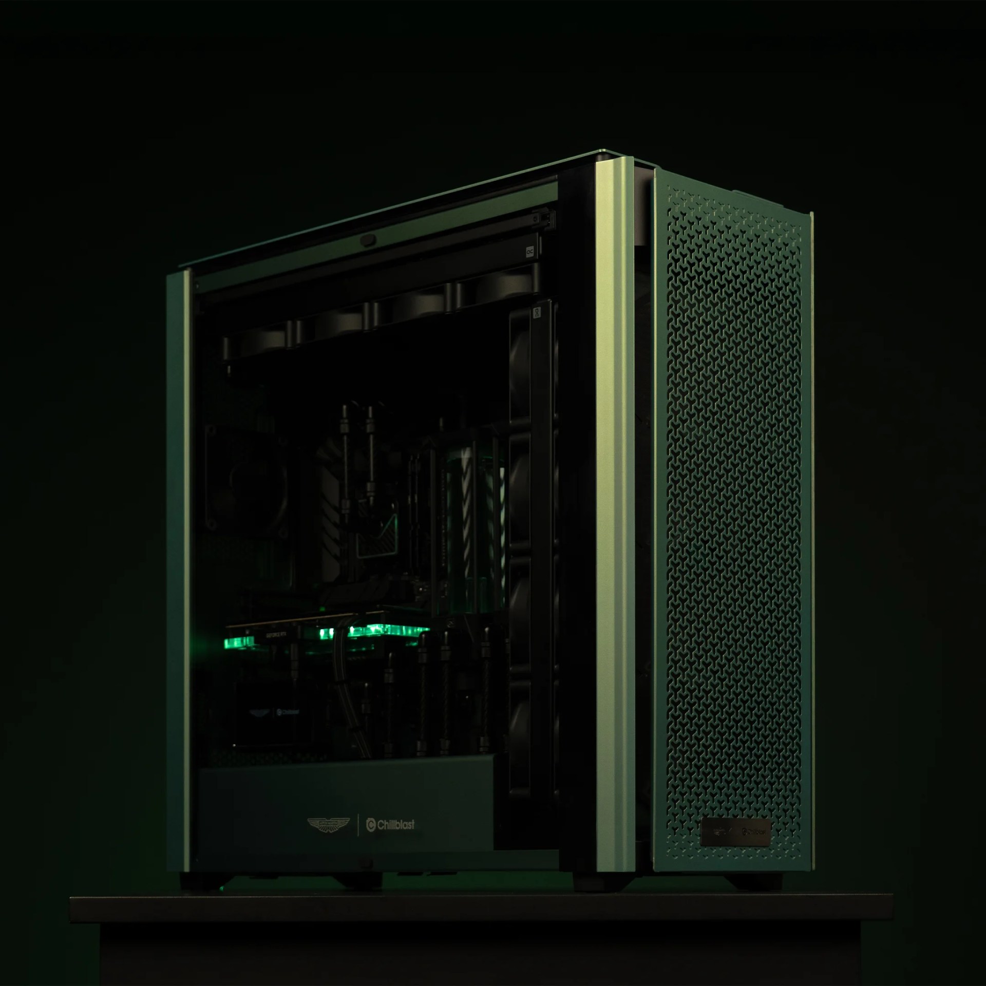 Green and black PC tower with mesh side panel and internal green LED lighting on a black surface.