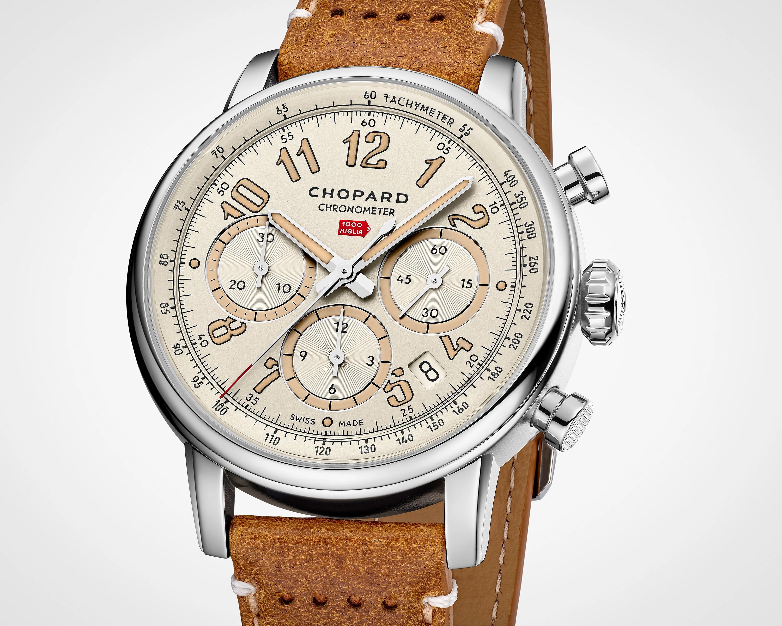 Close-up of a Chopard chronometer watch with a beige dial, three subdials, tachymeter scale, and a brown leather strap.