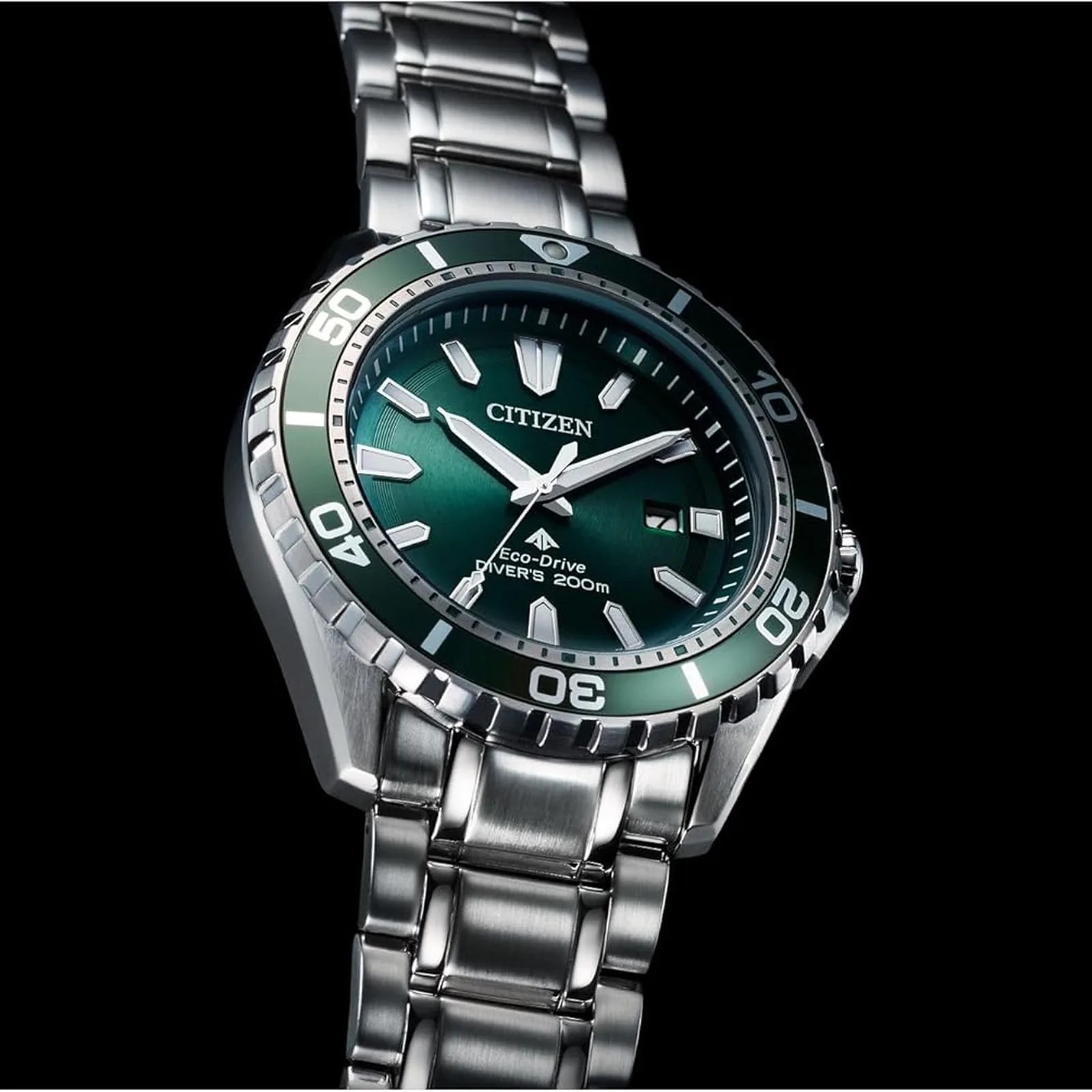 Silver Citizen Eco-Drive diver's watch with green bezel and dial on a metal bracelet.