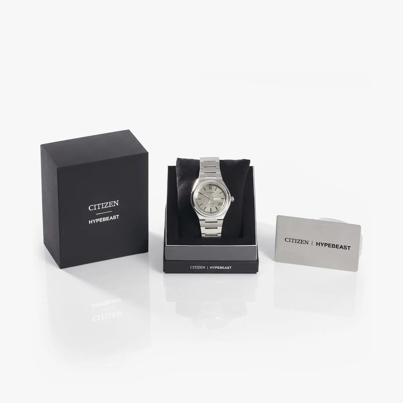 Silver Citizen wristwatch with metal band displayed on black cushion inside black Citizen Hypebeast box with a silver card.