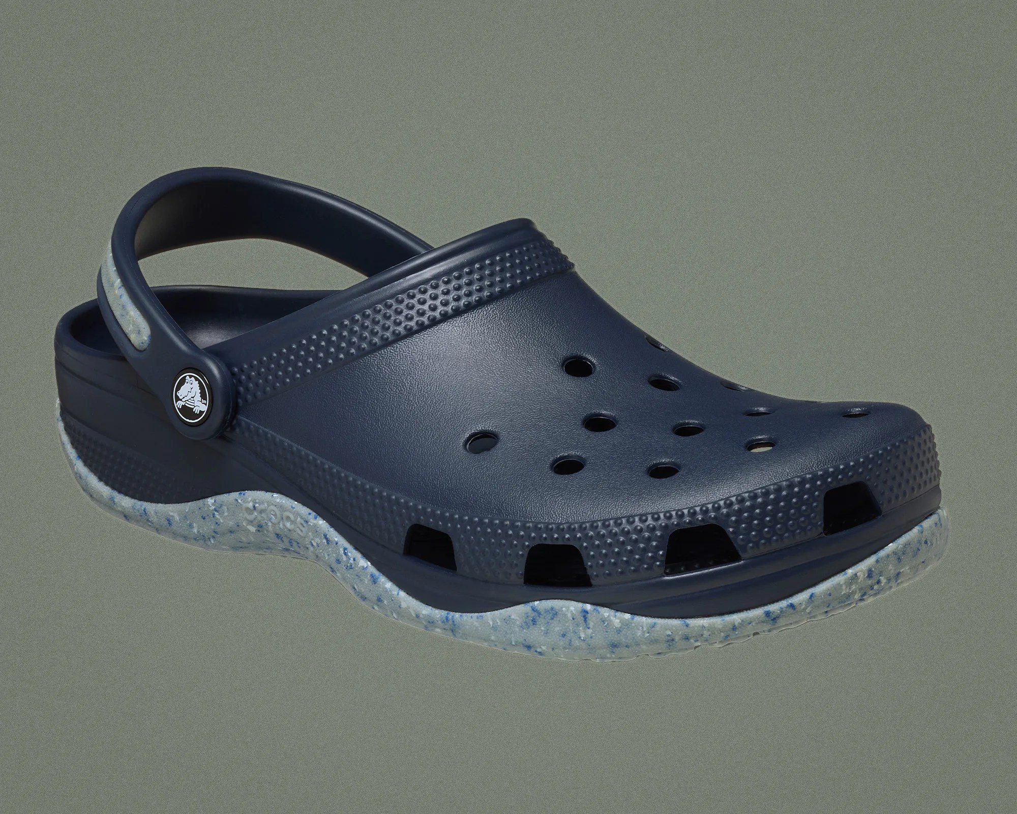 Navy blue Crocs clog with speckled light gray sole and adjustable heel strap.