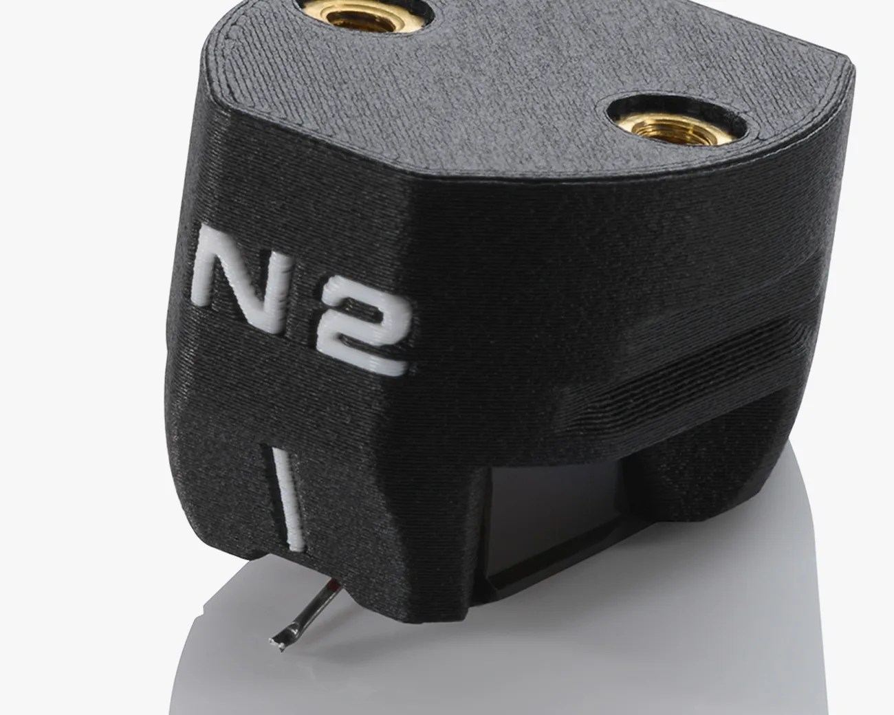 Black N2I phono cartridge with white lettering and metal stylus tip on a reflective surface.