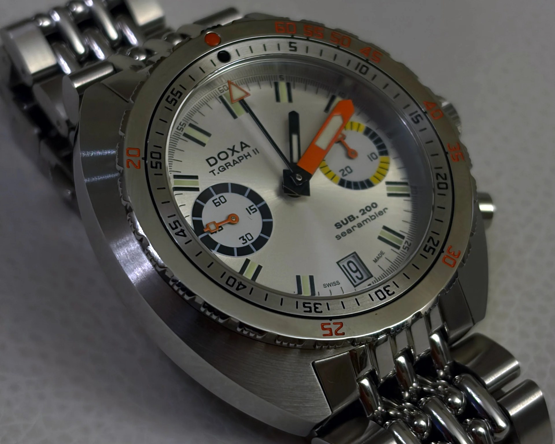 Silver DOXA T.Graph II SUB 200 searambler watch with orange and black hands and a metal link bracelet.