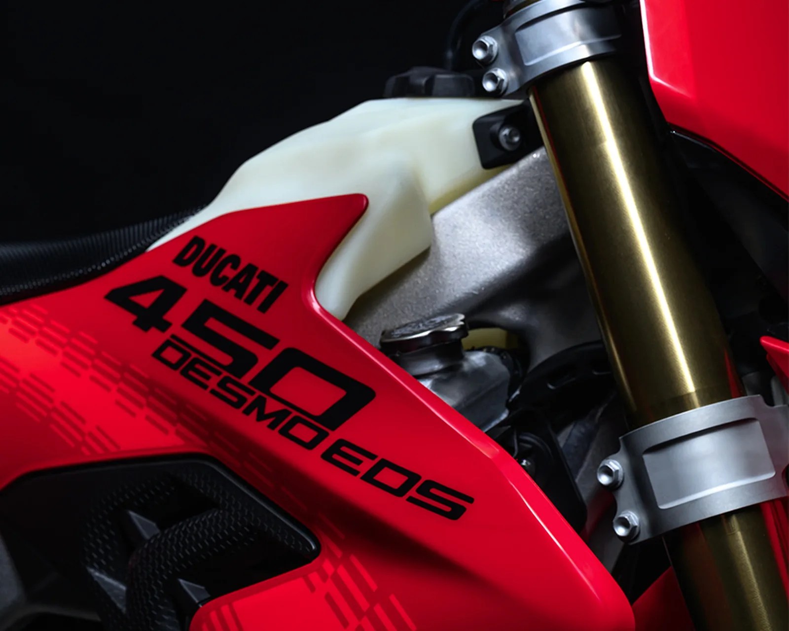 Close-up of red Ducati 450 Desmo EOS motorcycle frame with gold front fork and white plastic component.