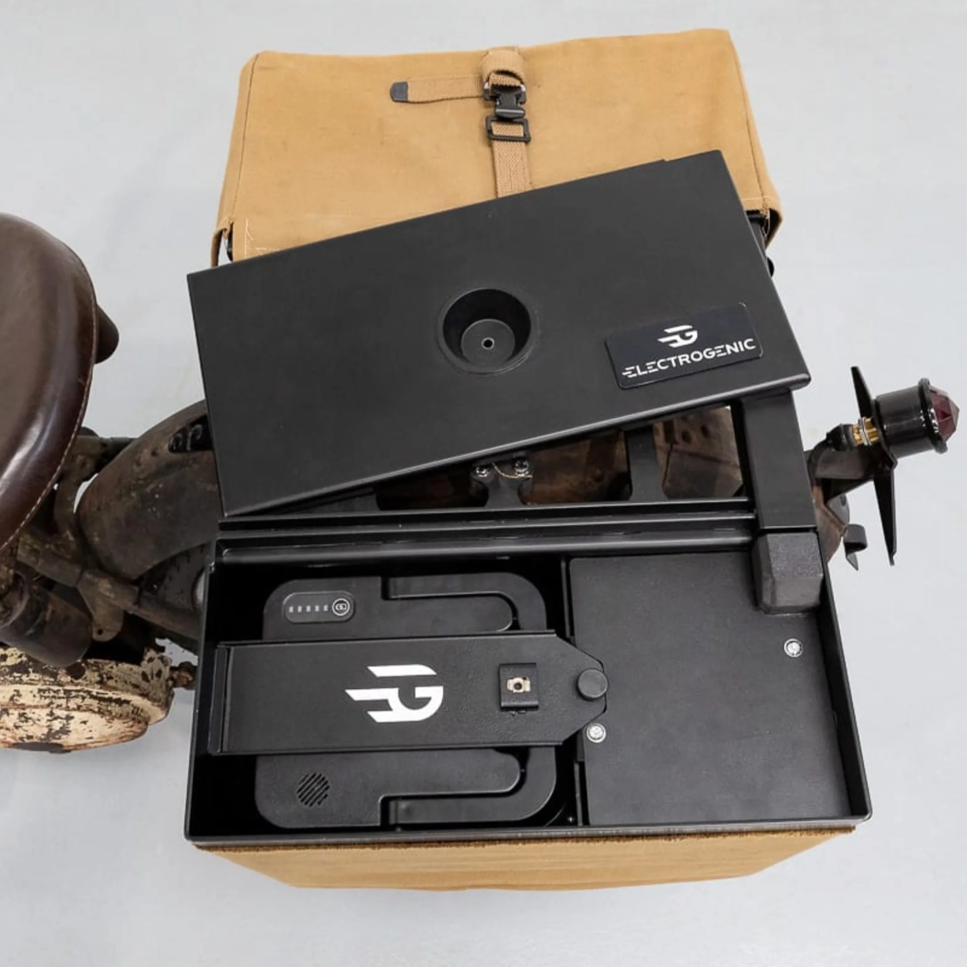 Black Electrogenic battery pack with logo inside a tan canvas bag on a white surface.