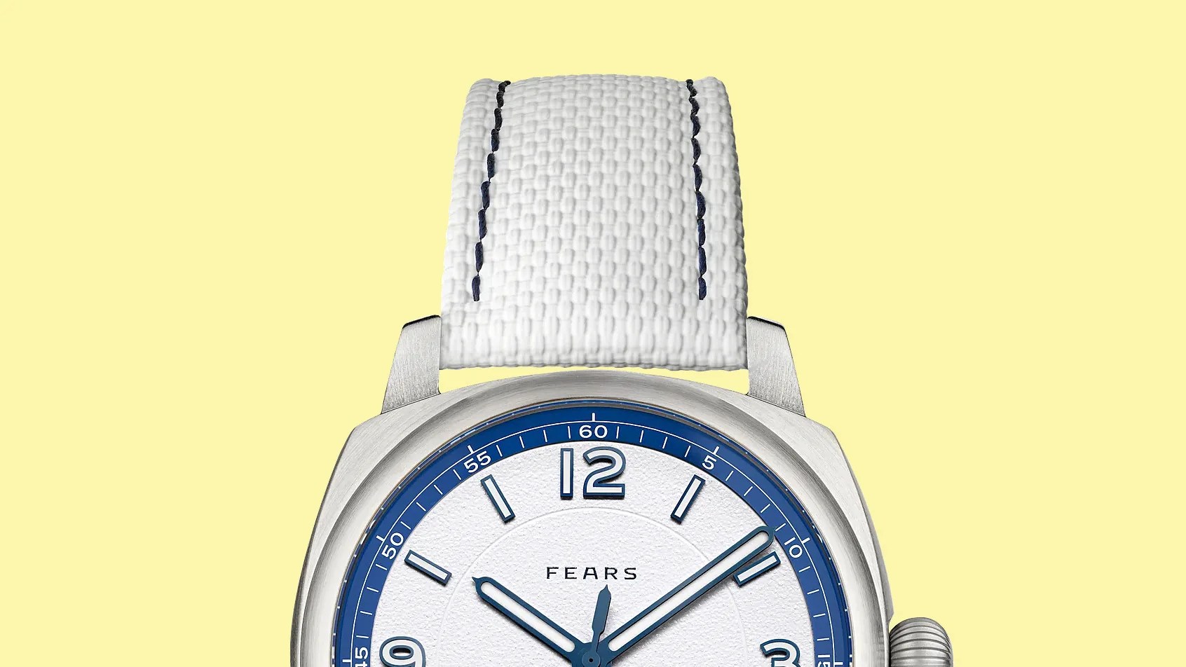 Close-up of a Fears wristwatch with a white textured dial, blue accents, and a white woven strap with dark stitching.