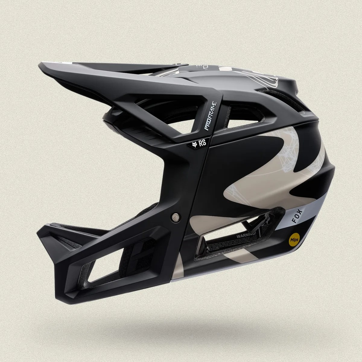 Black and beige full-face mountain bike helmet with Mips technology and Fox branding.
