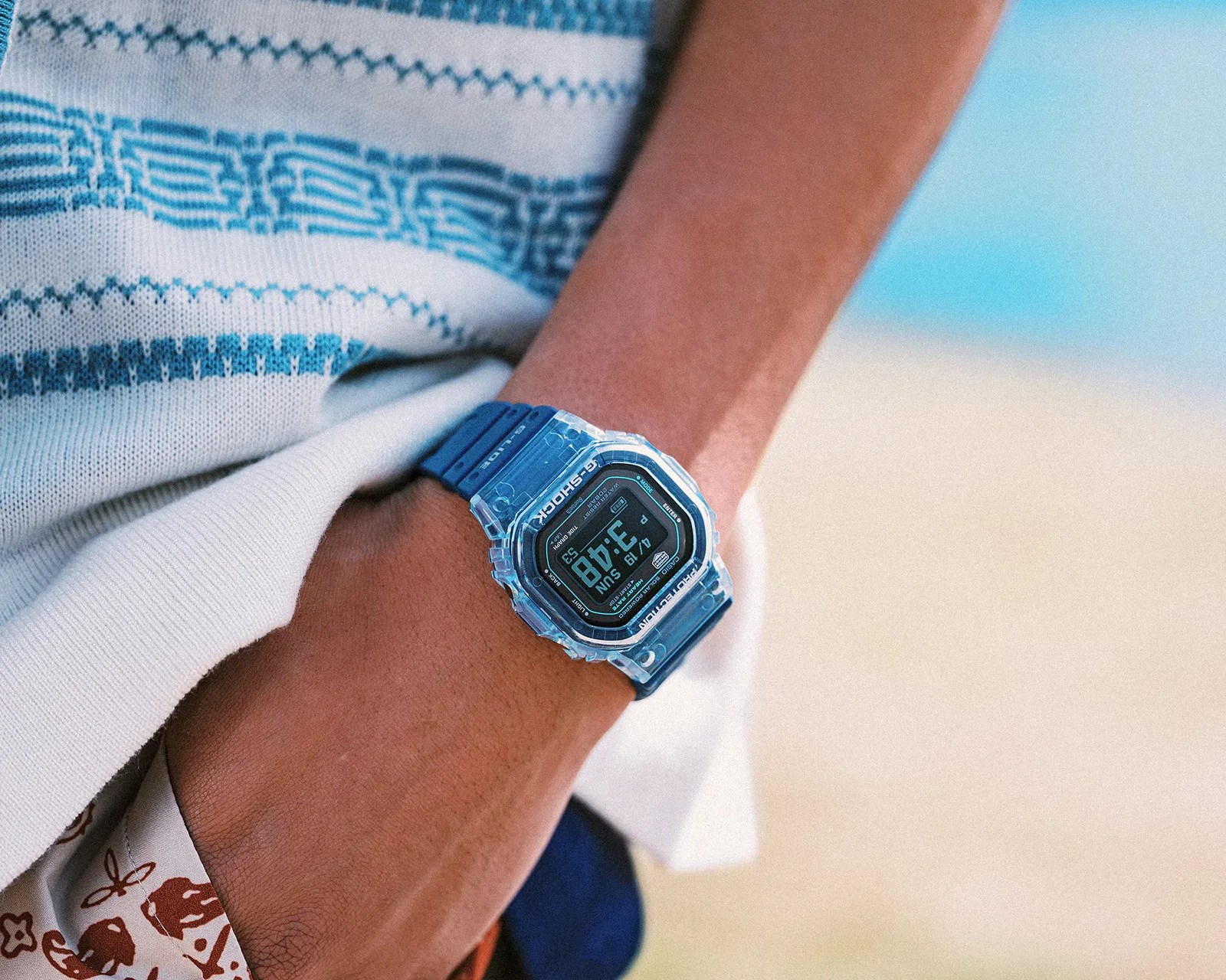 Blue Casio G-Shock digital watch with a transparent bezel worn on a wrist.