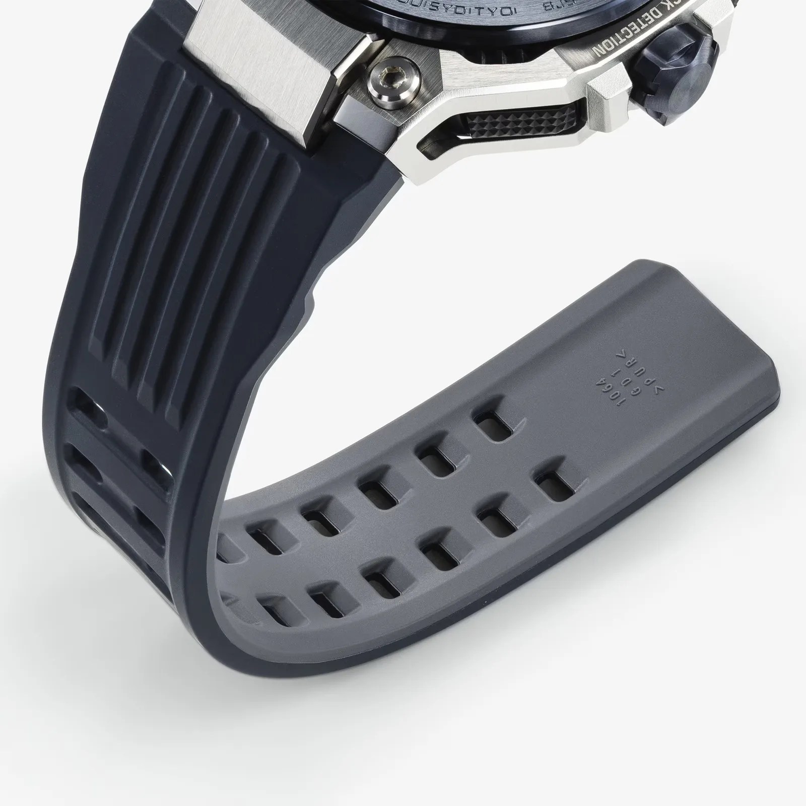 Close-up of a black and gray rubber watch strap attached to a silver metal watch case.