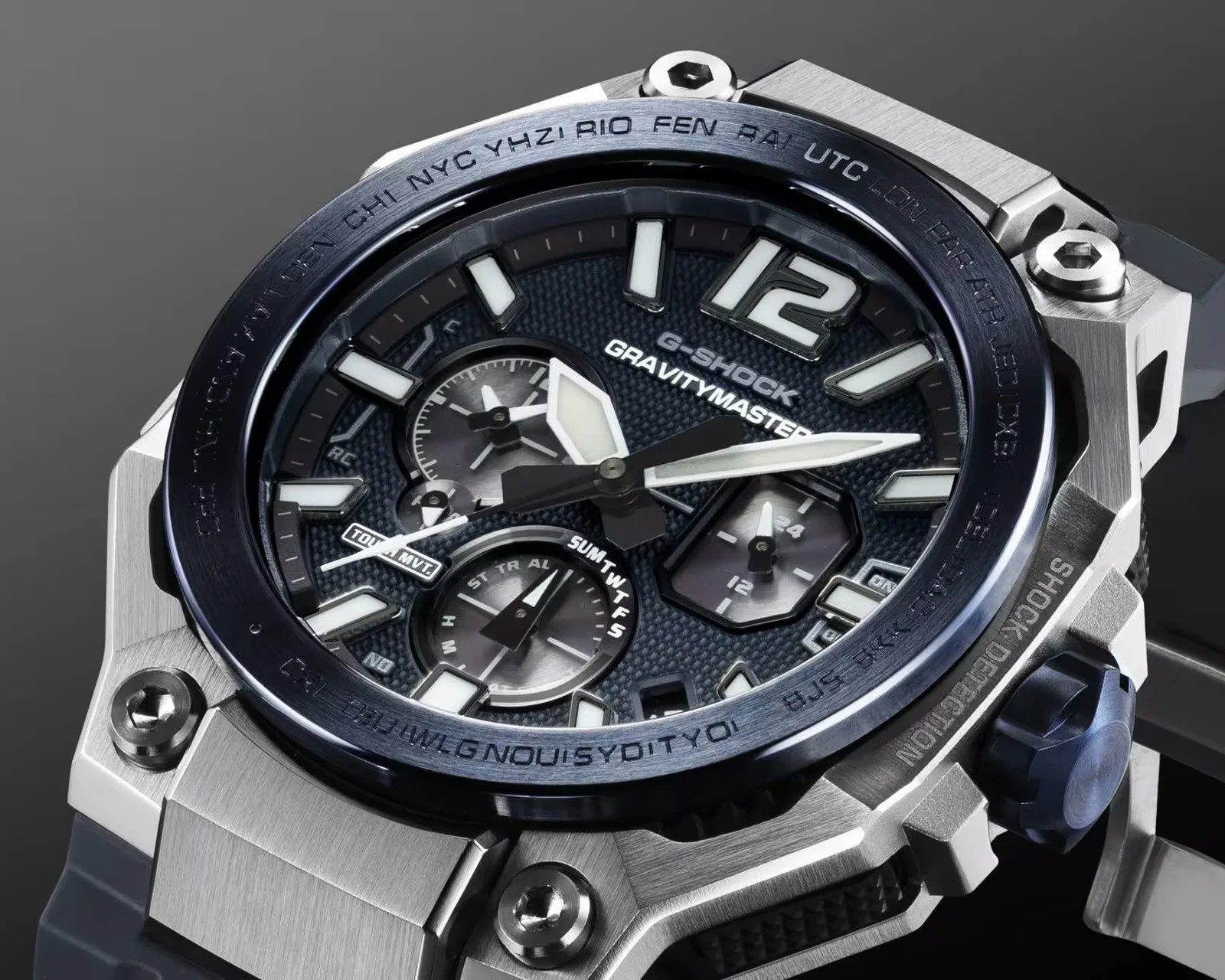 Close-up of a G-Shock Gravitymaster watch with a black textured dial, white luminous hands, and a silver metal case.
