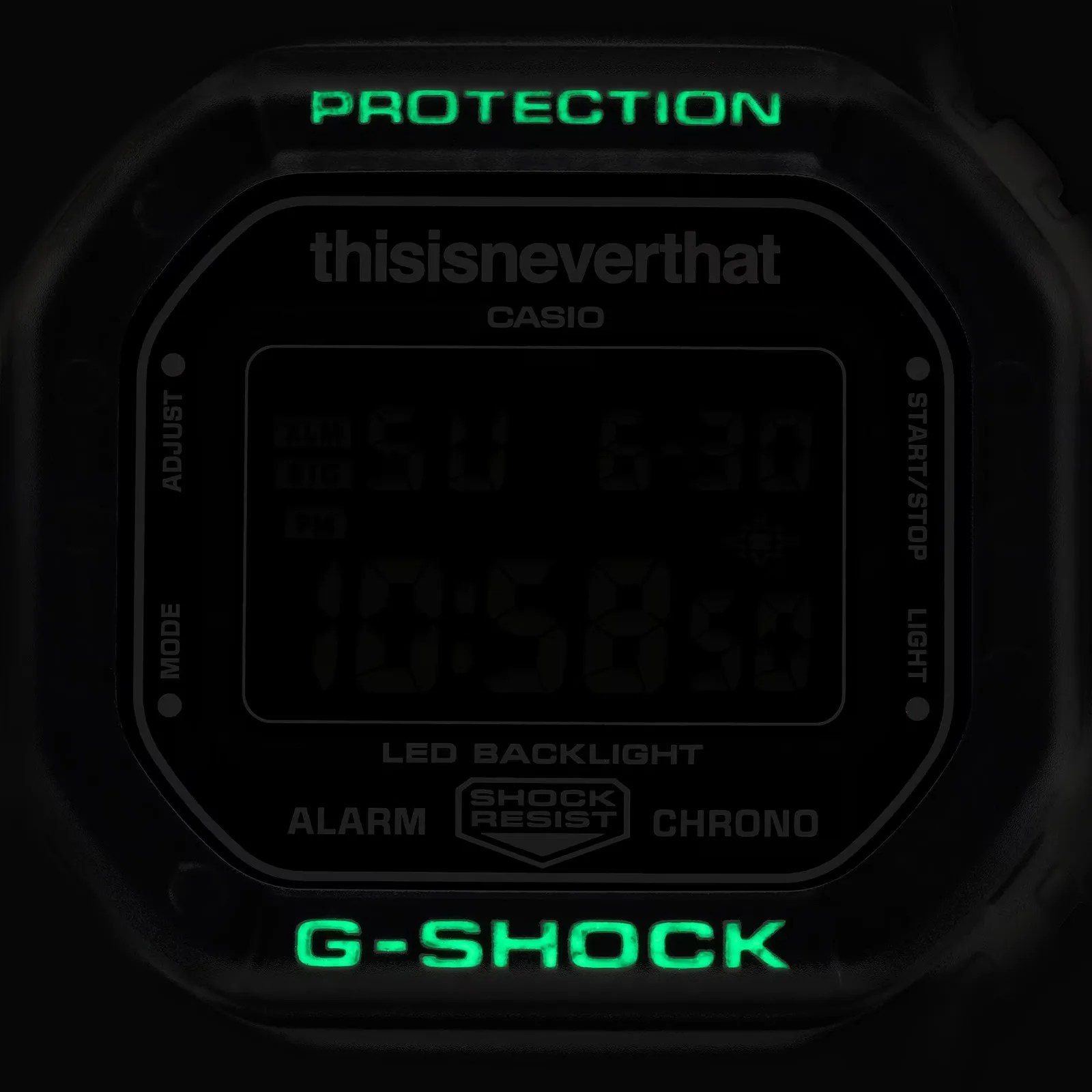 Close-up of a black Casio G-Shock digital watch face with green illuminated "PROTECTION" and "G-SHOCK" text.