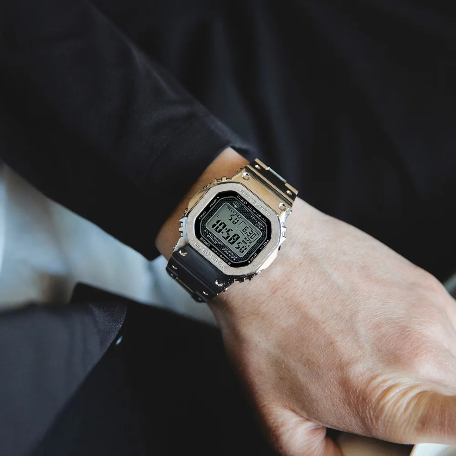 Silver Casio G-Shock digital watch with black strap worn on a wrist.