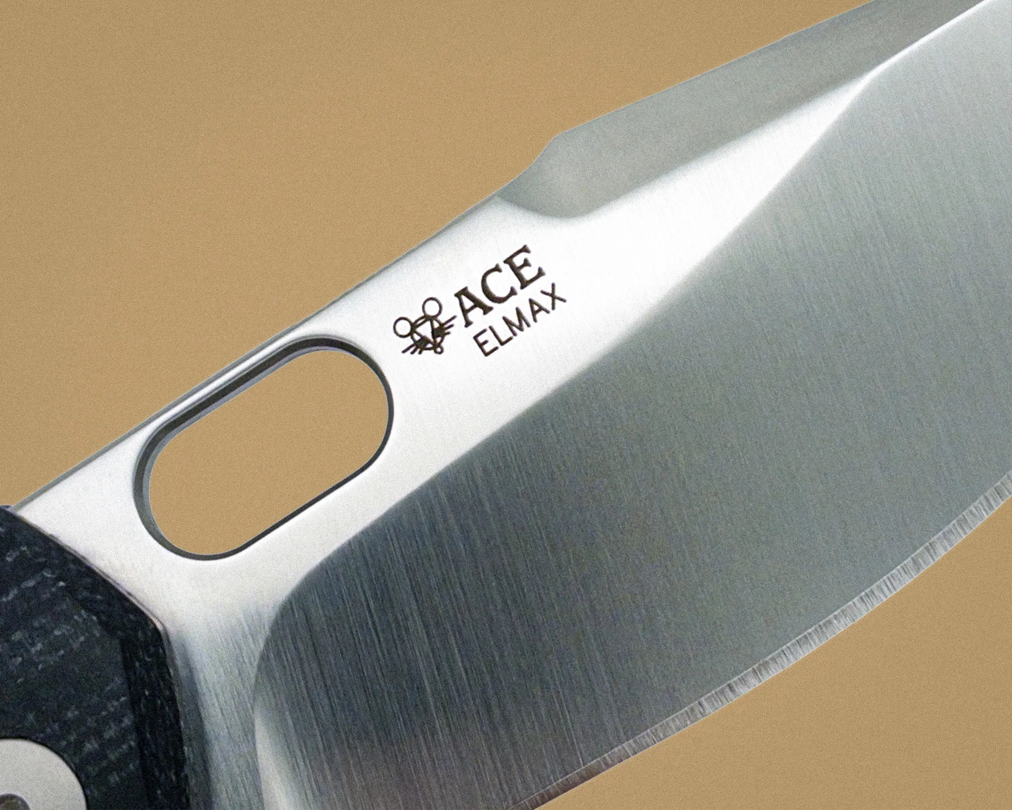 Close-up of a stainless steel knife blade with "ACE ELMAX" logo and a textured black handle.