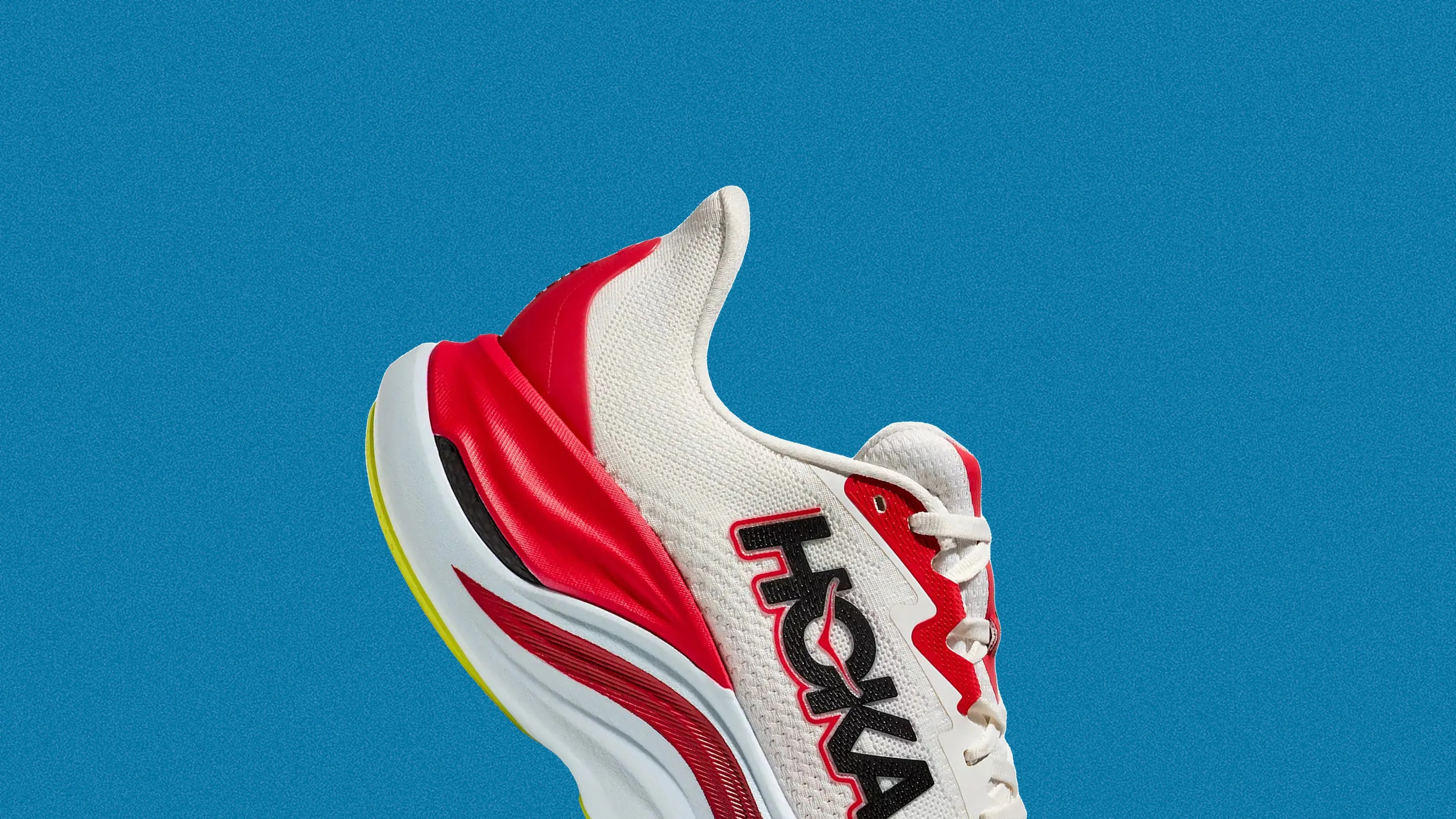 White and red athletic shoe with black "HOKA" logo on the side against a blue background.