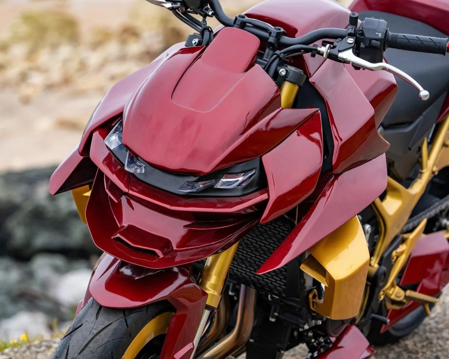 Close-up of a red and gold motorcycle front with angular fairings and dual headlights.