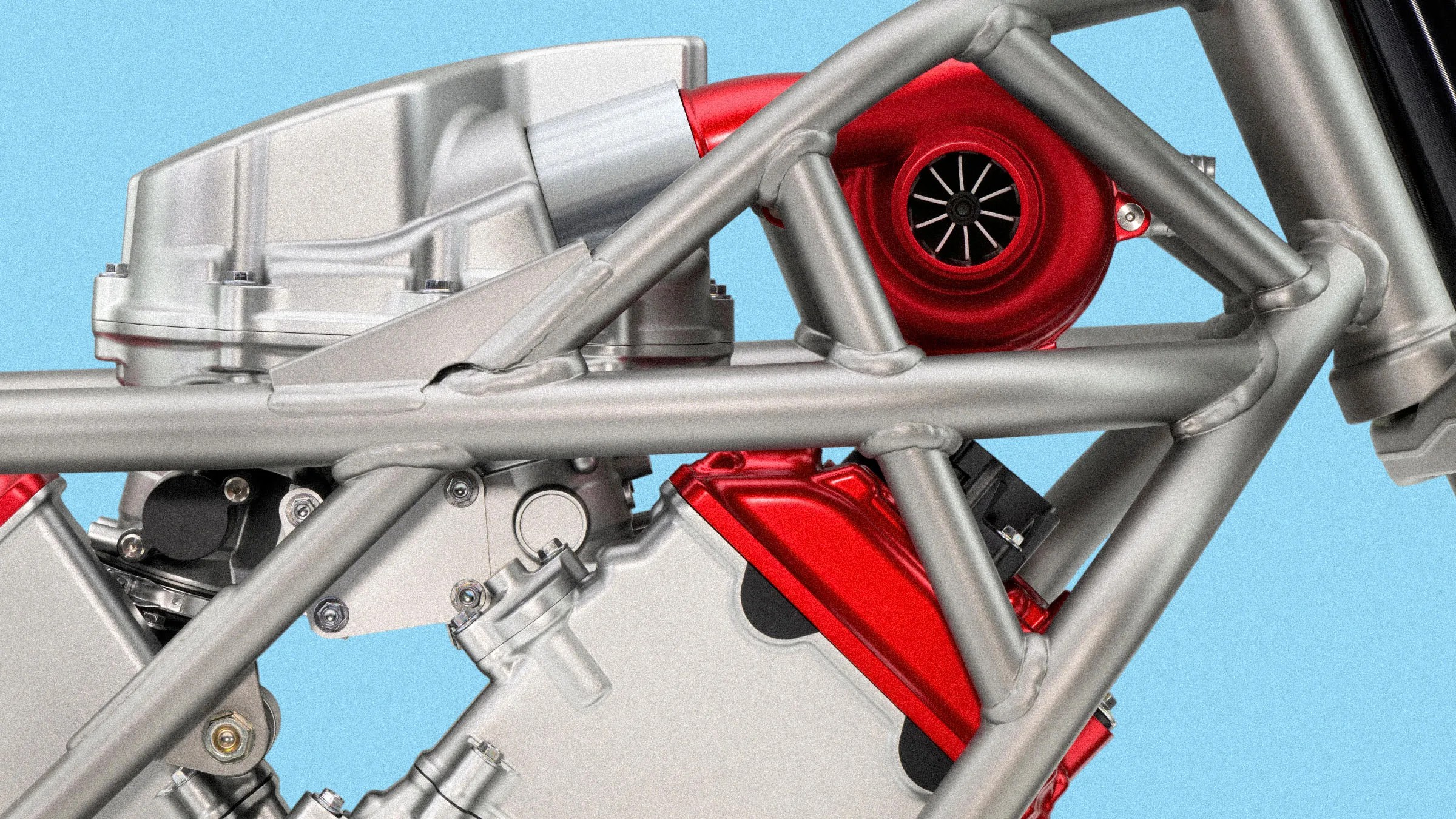 Close-up of a metallic motorcycle frame with a red turbocharger and engine components against a blue background.
