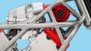 Close-up of a metallic motorcycle frame with a red turbocharger and engine components against a blue background.