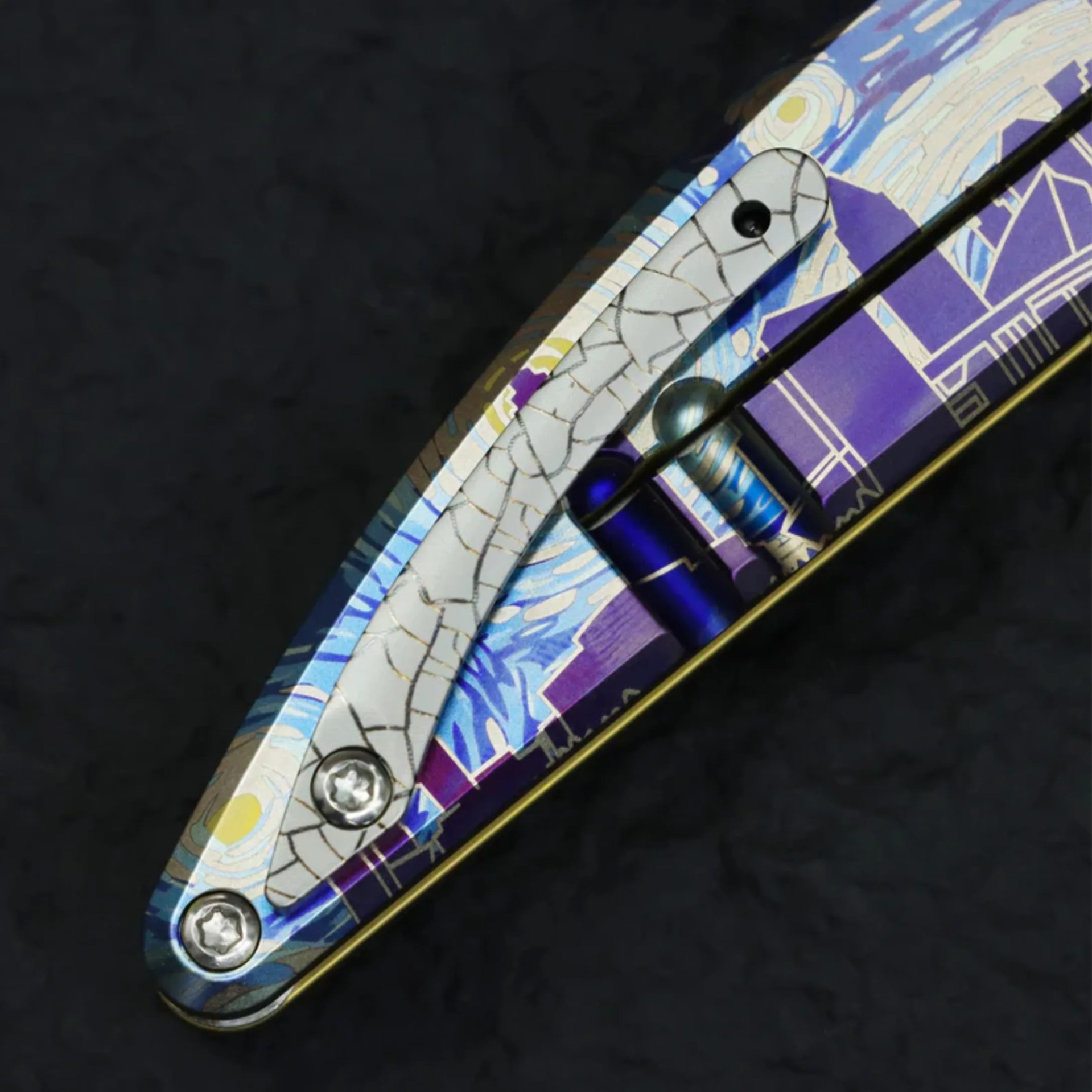 Close-up of a folding knife handle with a colorful, intricate pattern and two visible screws.