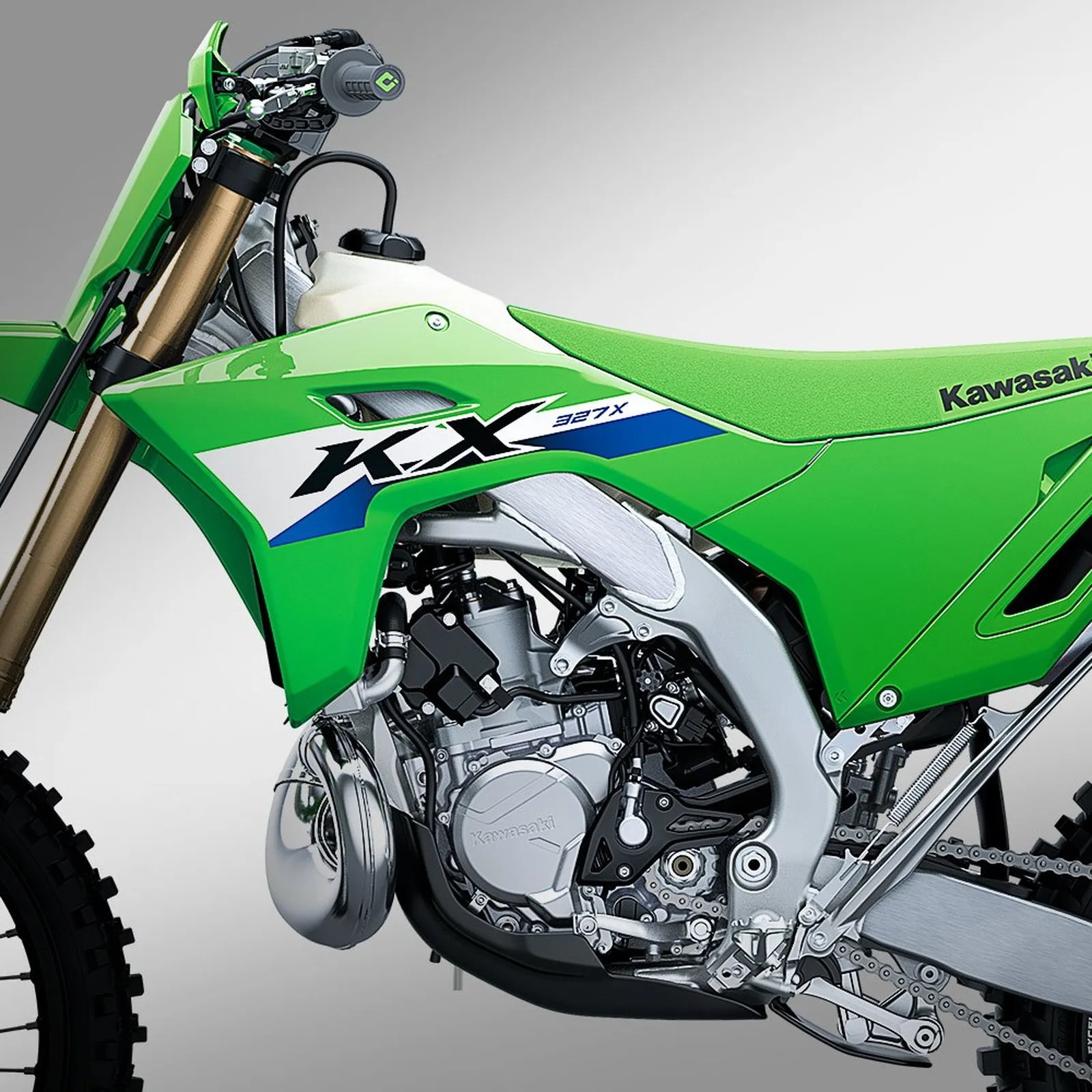 Green Kawasaki KX 327X dirt bike with visible engine and suspension components.