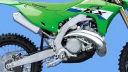 Close-up of the engine and rear wheel area of a green Kawasaki KX dirt bike against a blue background.
