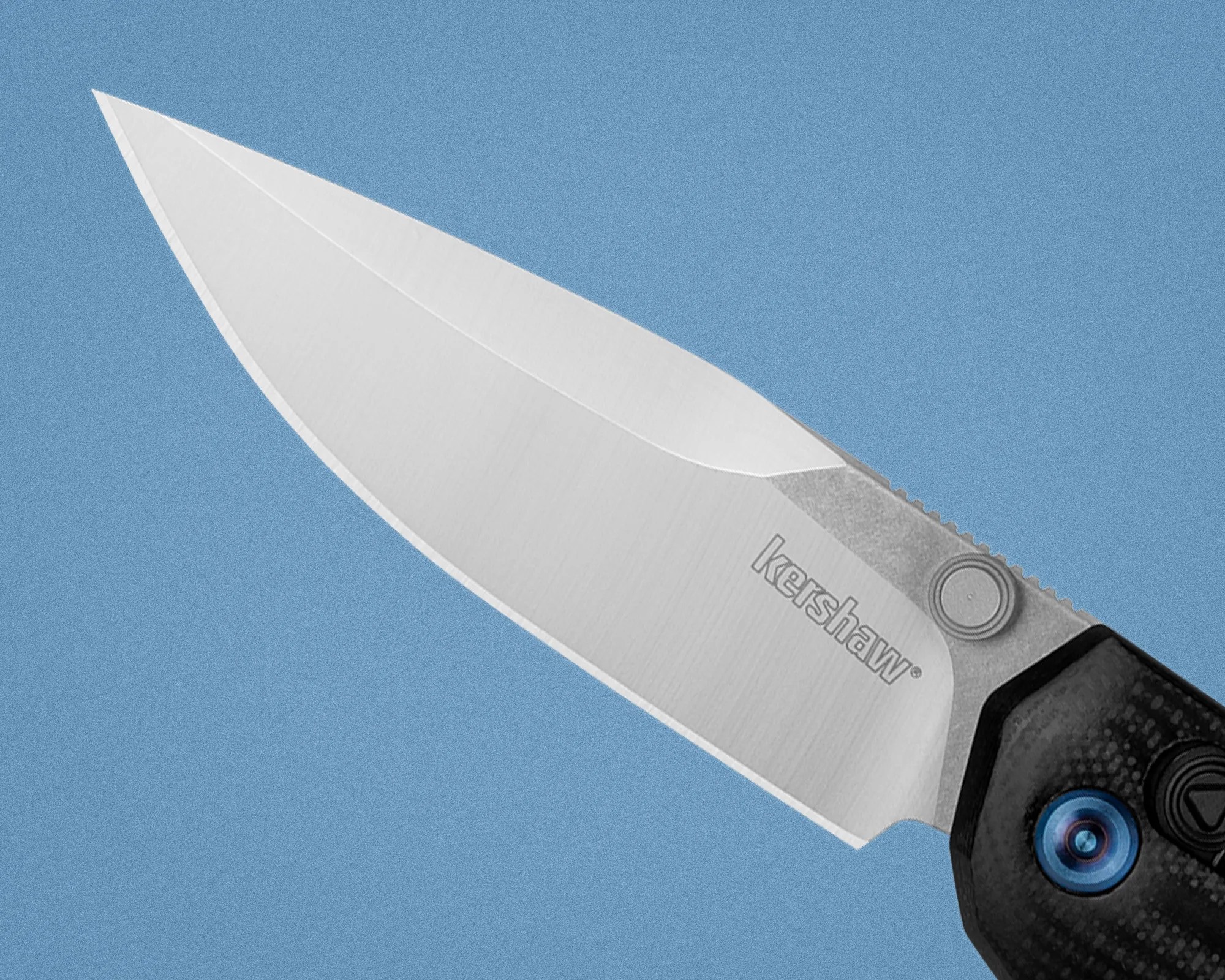 Close-up of a Kershaw folding knife blade with a textured handle and blue pivot screw on a blue background.