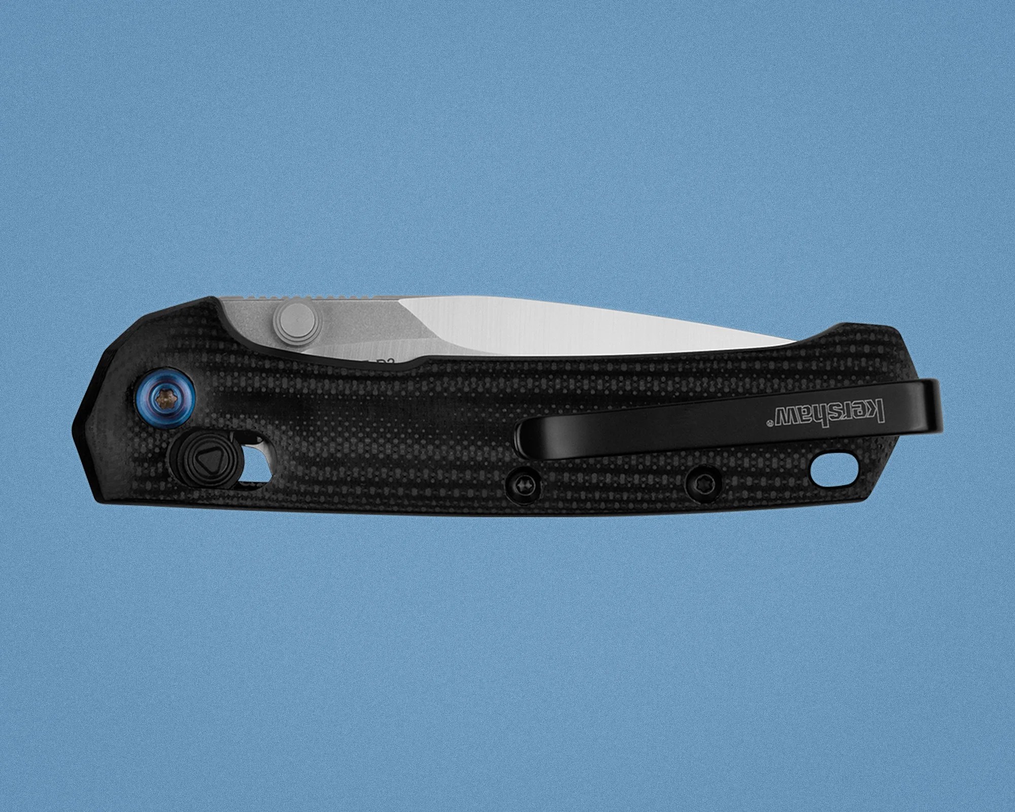 Black textured folding knife with partially visible silver blade and black clip labeled "Kershaw" on blue background.