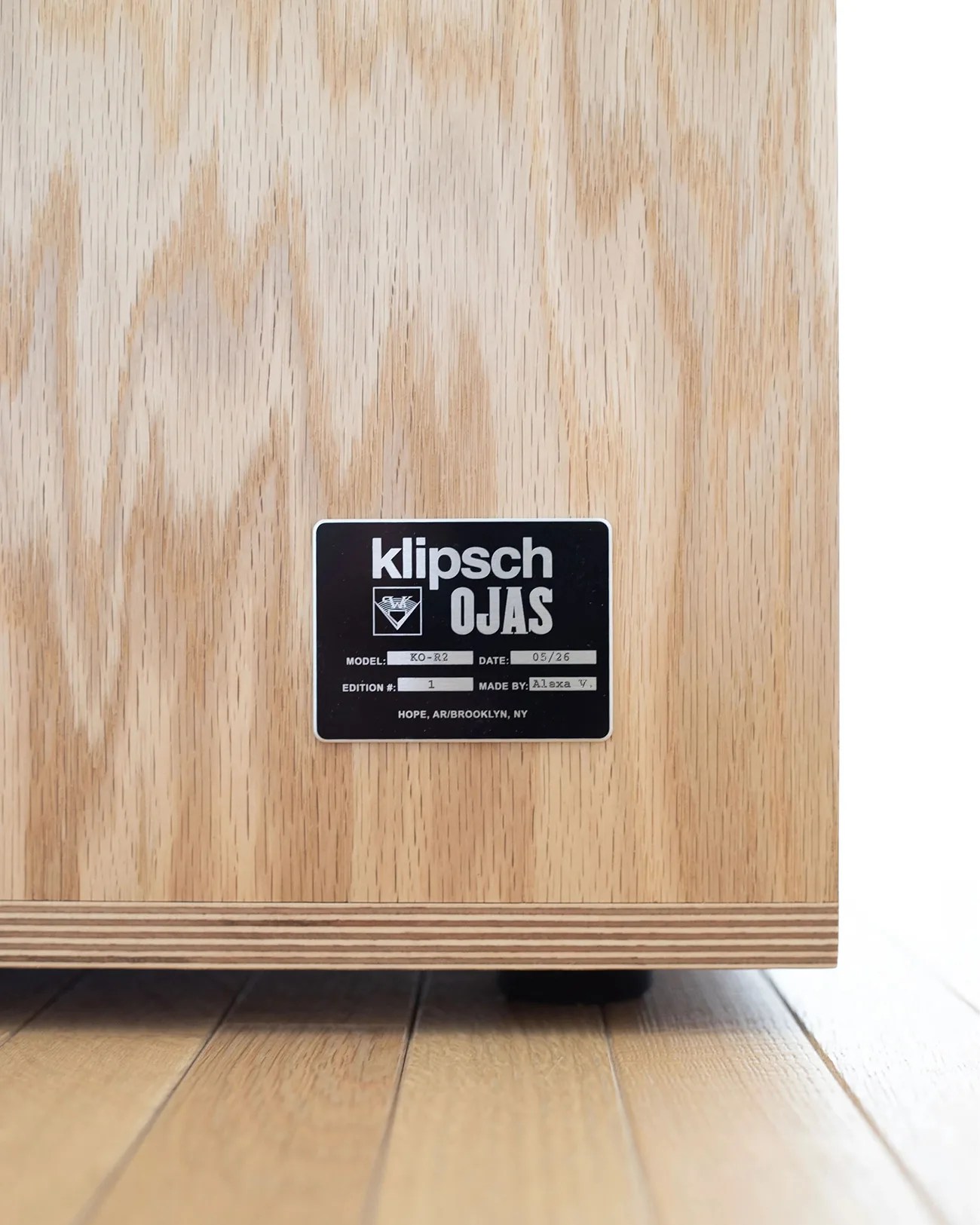 Black and silver Klipsch OJAS model label on light wood speaker cabinet.