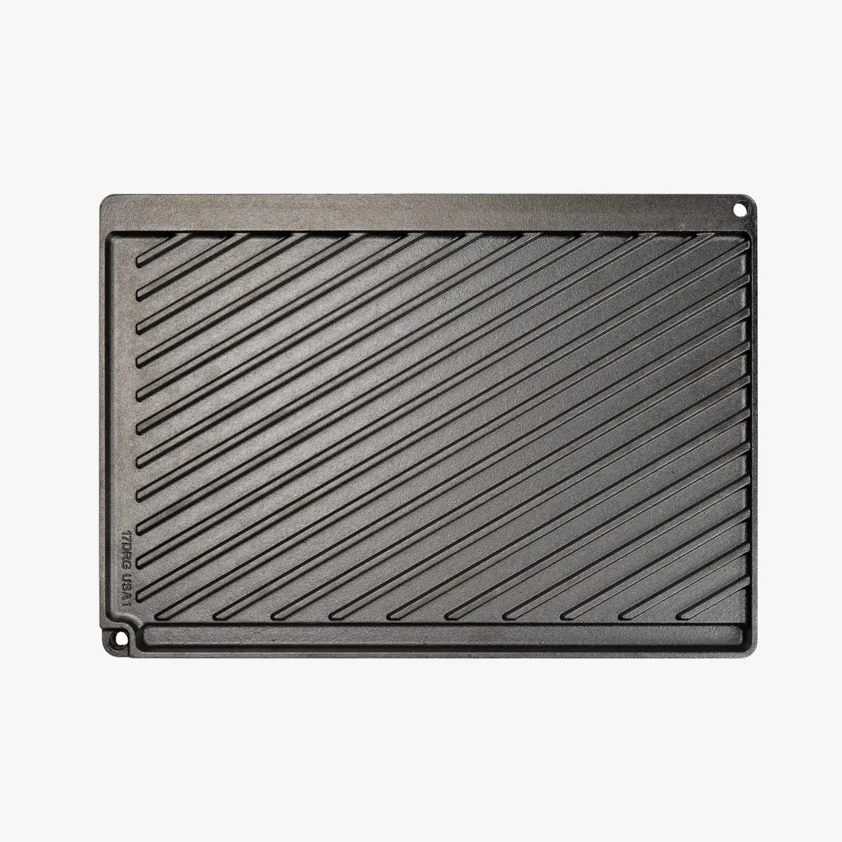 Rectangular black cast iron grill pan with diagonal ridges and a small hole in one corner.