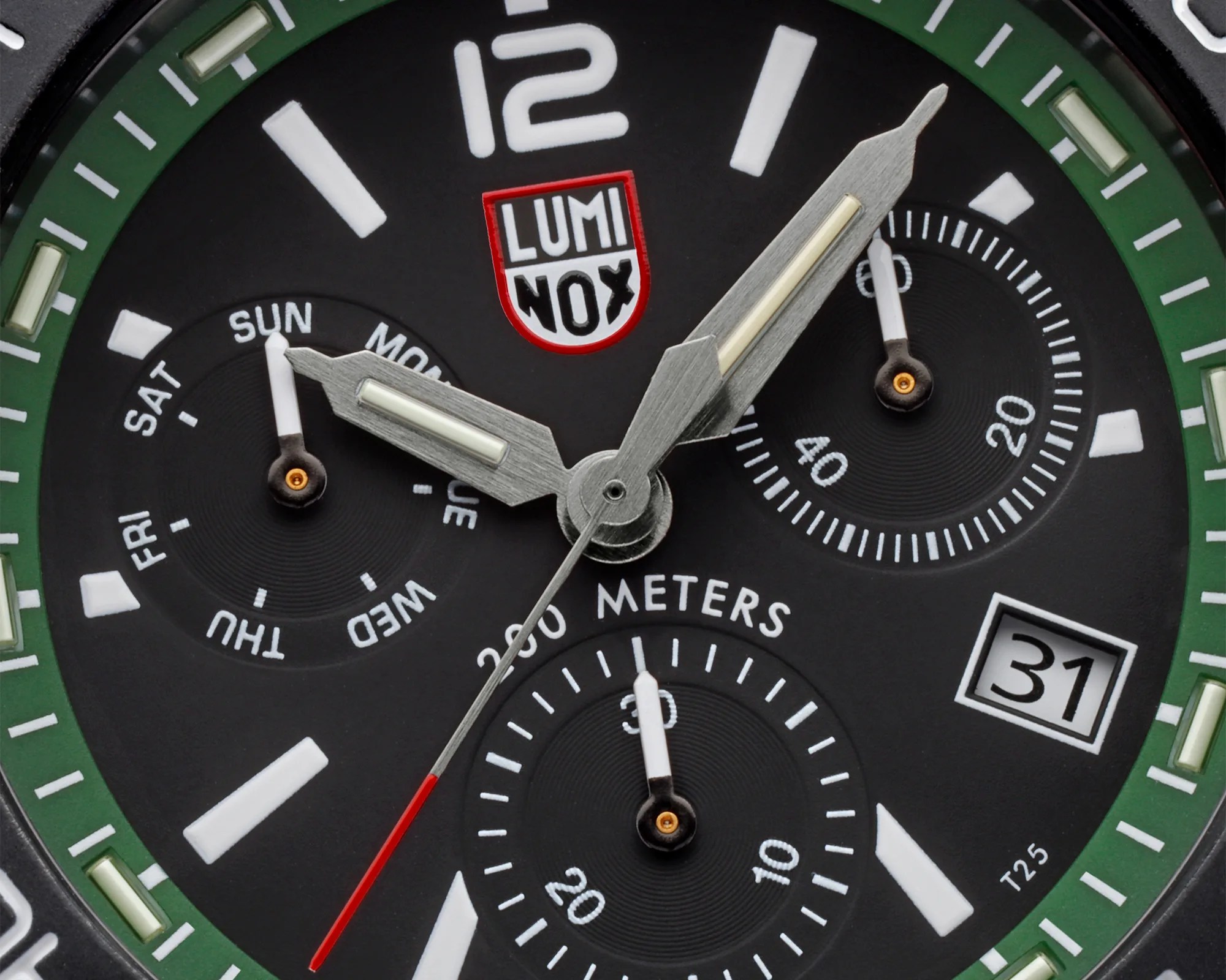Close-up of a Luminox watch face with green bezel, silver hands, red second hand, day and date subdials.