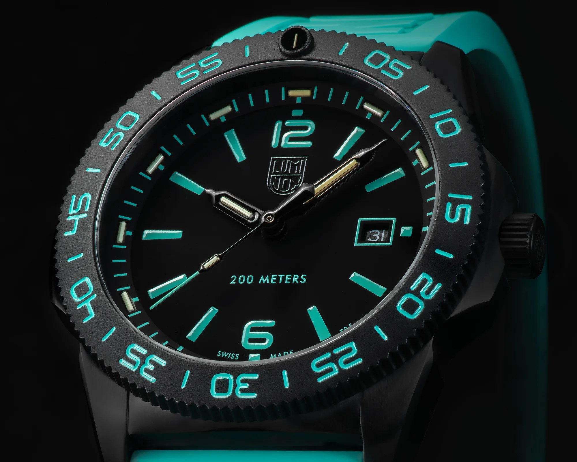 Black Luminox watch with glowing turquoise numerals and markers, turquoise rubber strap, and date display.