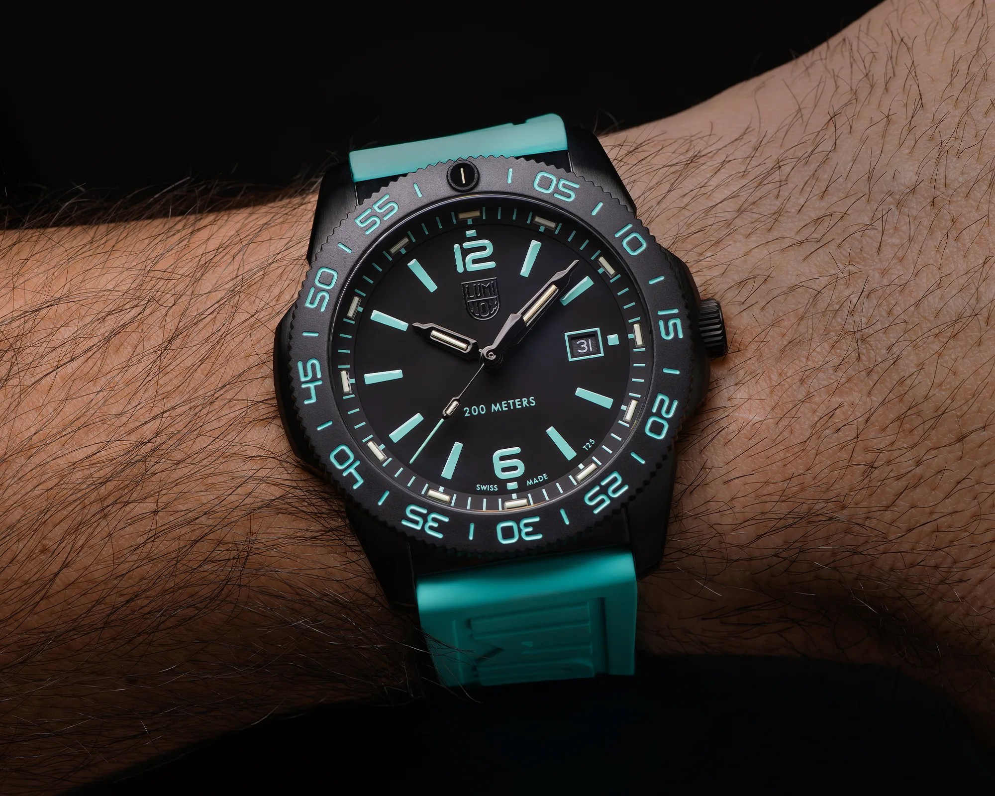 Black Luminox wristwatch with turquoise luminescent markers and bezel numbers, turquoise strap, and date display on a wrist.