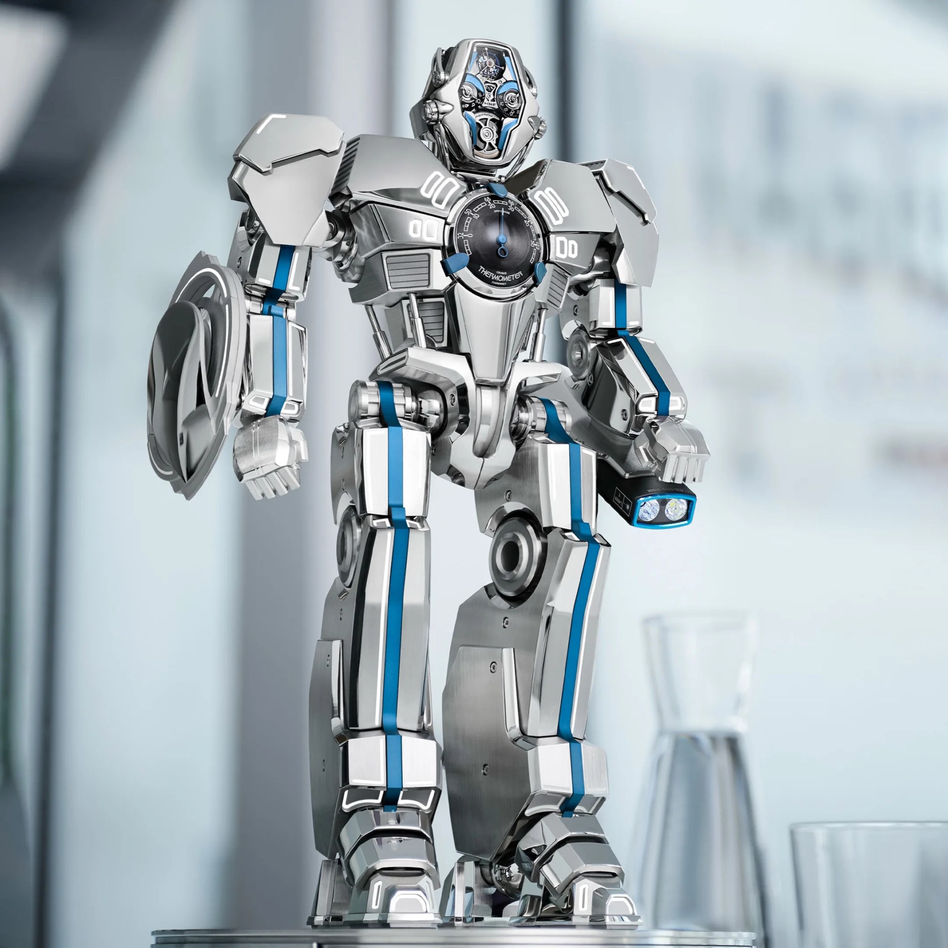 Silver and blue robot with a thermometer dial on its chest standing on a metallic surface.