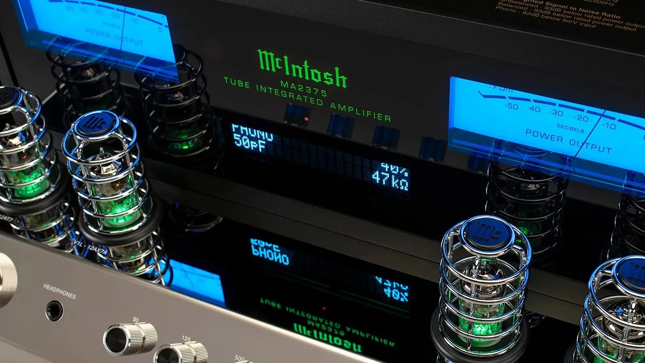 Close-up of a McIntosh MA2375 tube integrated amplifier with glowing green tubes and blue power output meters.