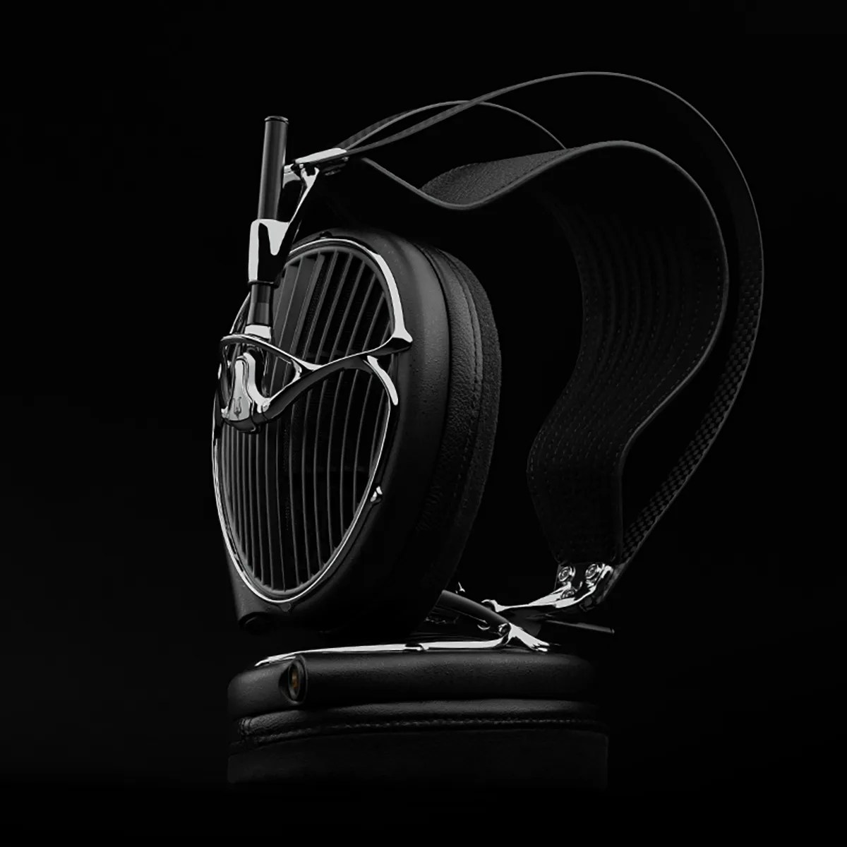 Black over-ear headphones with silver metal accents and a textured headband on a black background.