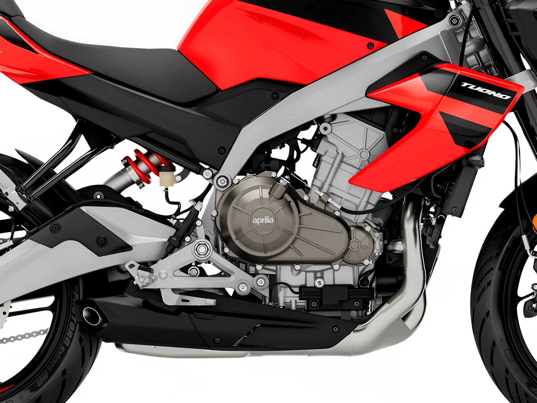 Close-up of a red and black Aprilia Tuono motorcycle engine and frame with visible suspension and exhaust components.