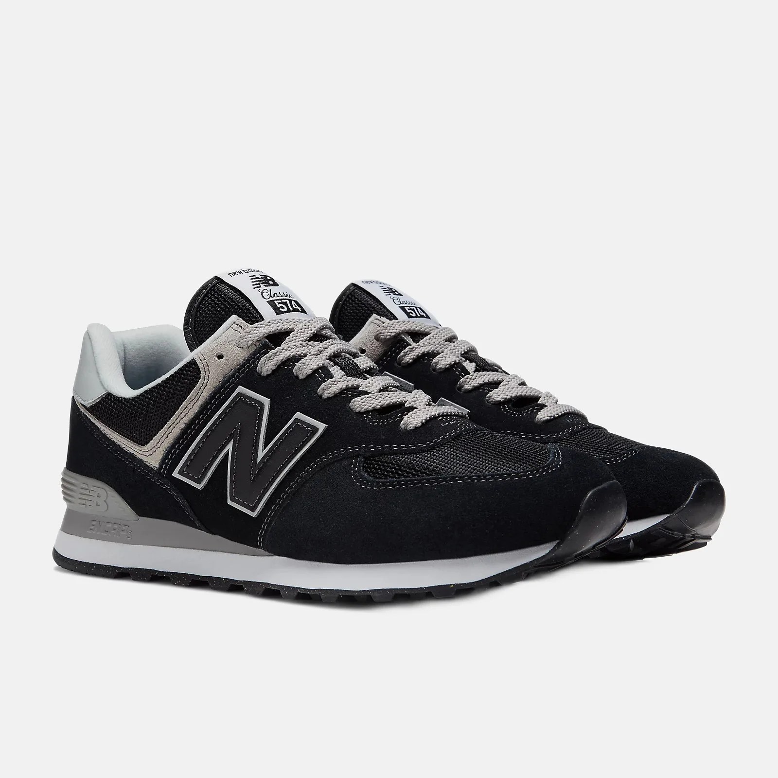 Pair of black and gray New Balance 574 sneakers with white midsoles and gray laces on a white background.